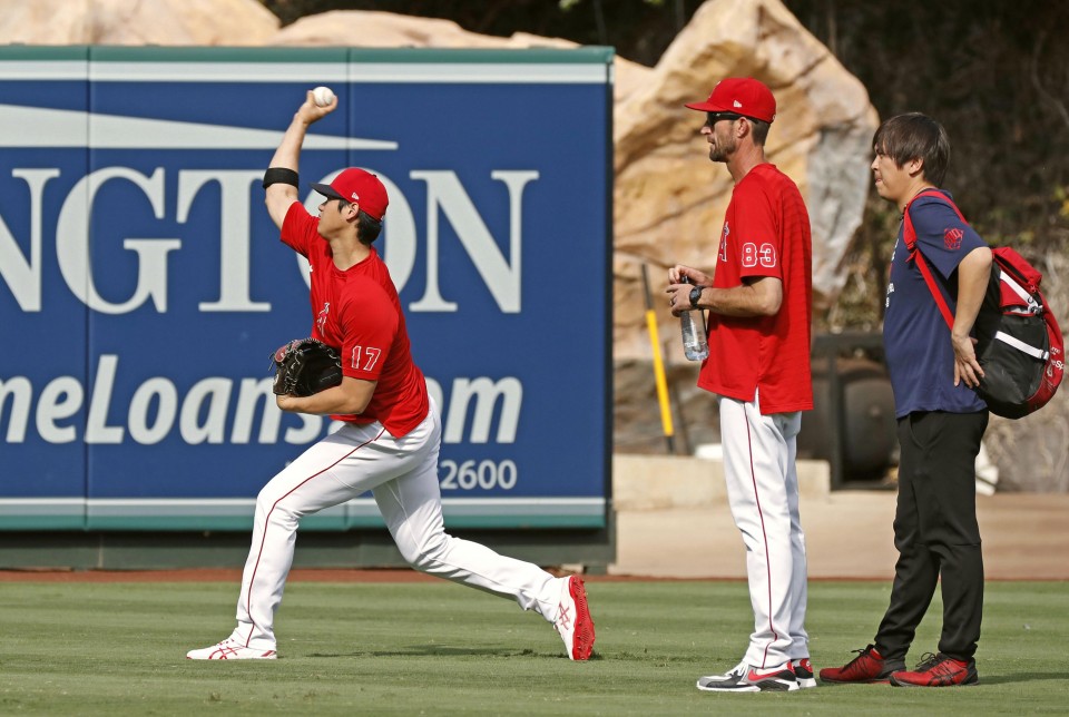 Shohei Ohtani of the Los Angeles Angels grabs his right forearm as