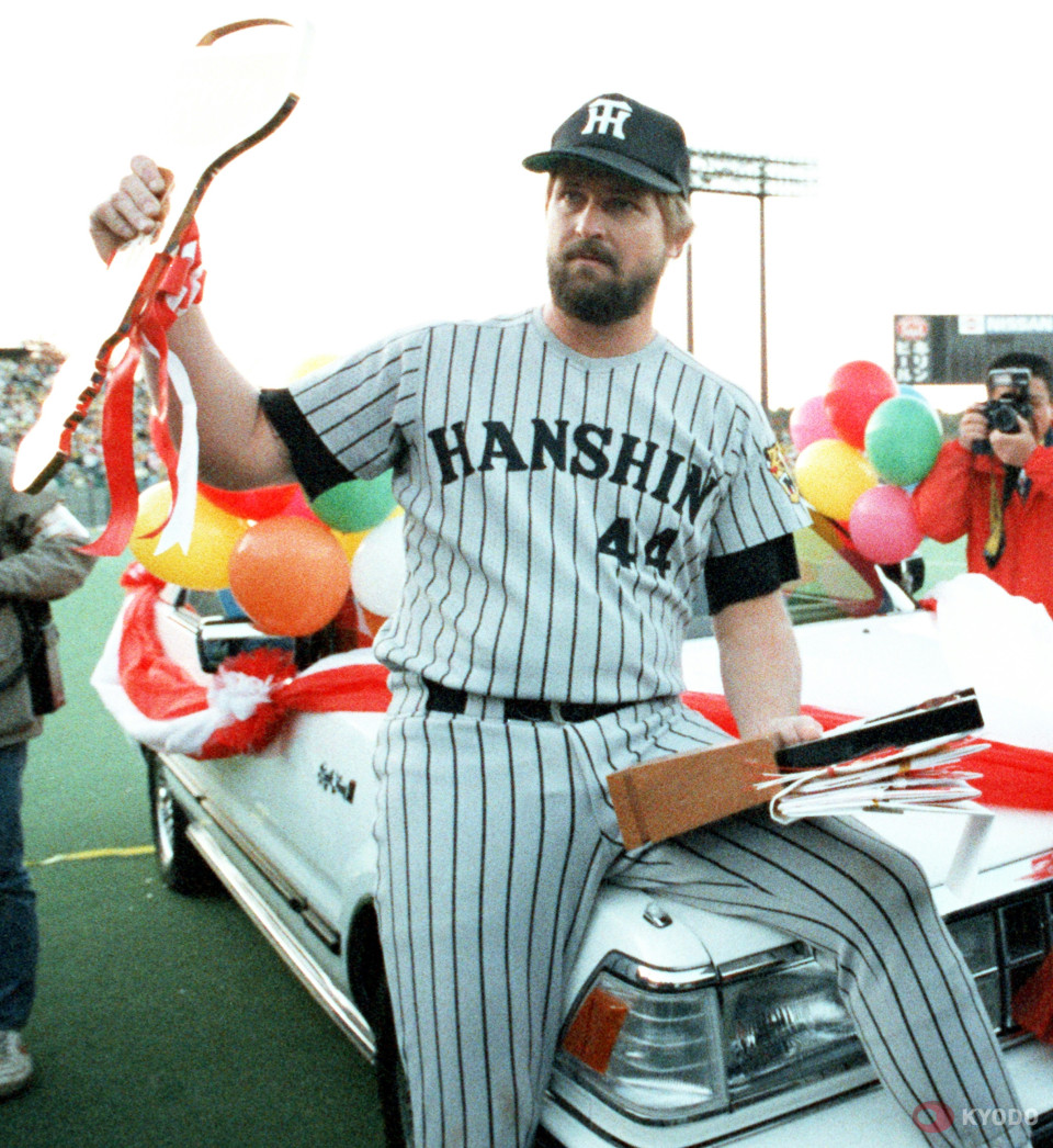 DeNA BayStars manager Alex Ramirez (R) receives flowers from